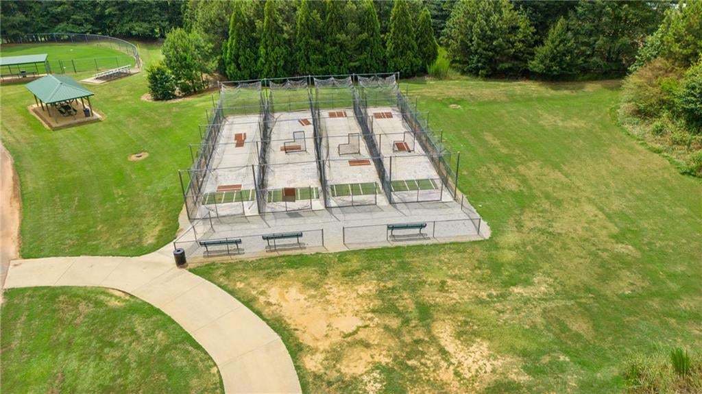 Outdoor batting cage facility featuring multiple practice bays, a covered picnic area, and extensive green space