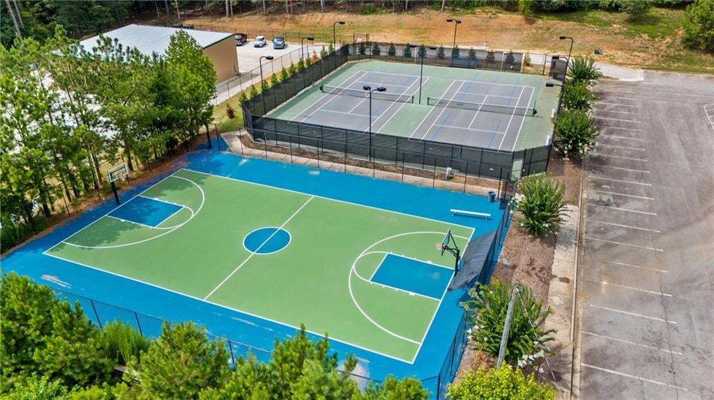 Basketball court featuring a vibrant green and blue surface with perimeter fencing