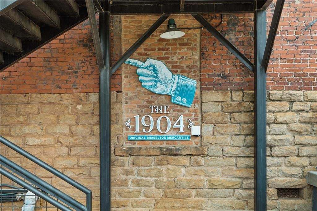 Exterior brick and stone facade featuring a decorative sign with "The 1904 Original Braselton Mercantile" lettering