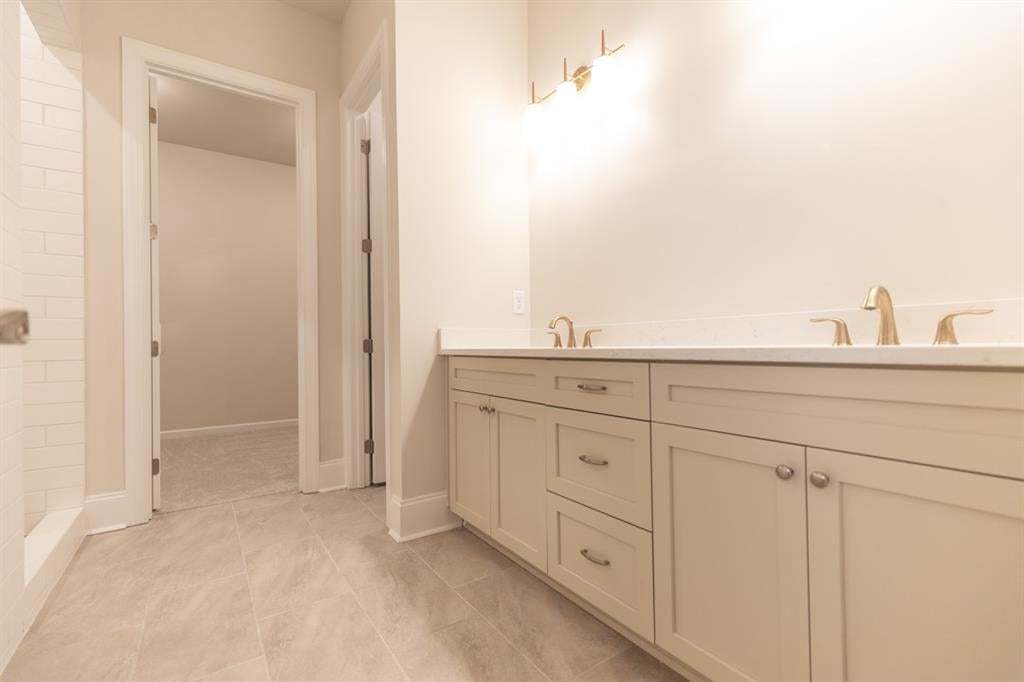 Primary bathroom featuring dual sinks, ample storage, primary closet. The walk-in shower is beautiful!  Photo is for representation purposes only, not of actual home but a previously built home by The Providence group.