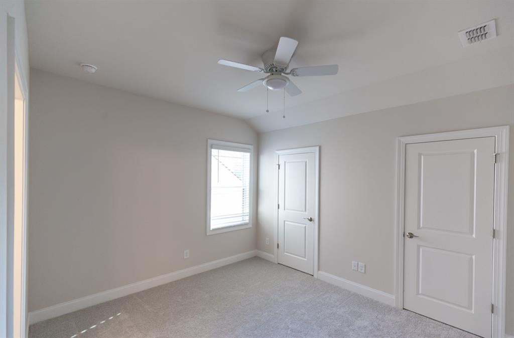 Sloped ceiling, light gray carpeting, ceiling fan, and white window blinds