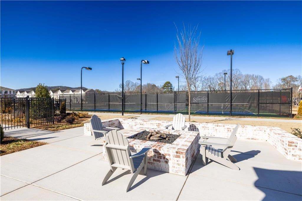 Outdoor patio featuring a brick fire pit, concrete pavers, and a surrounding brick wall