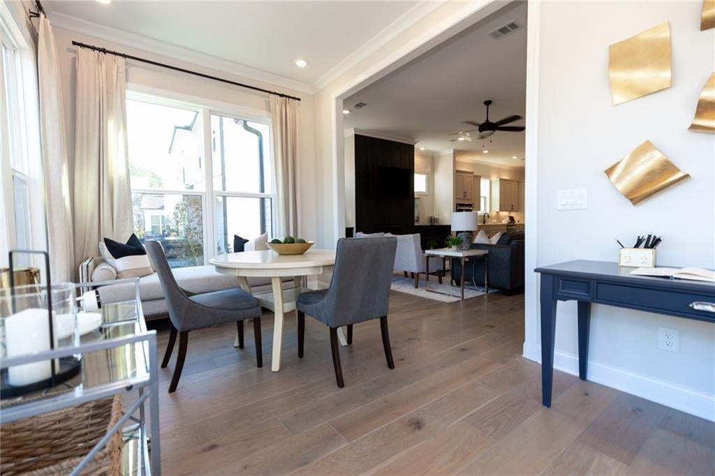 Wood-finish flooring throughout, recessed lighting, and a large window with white casing