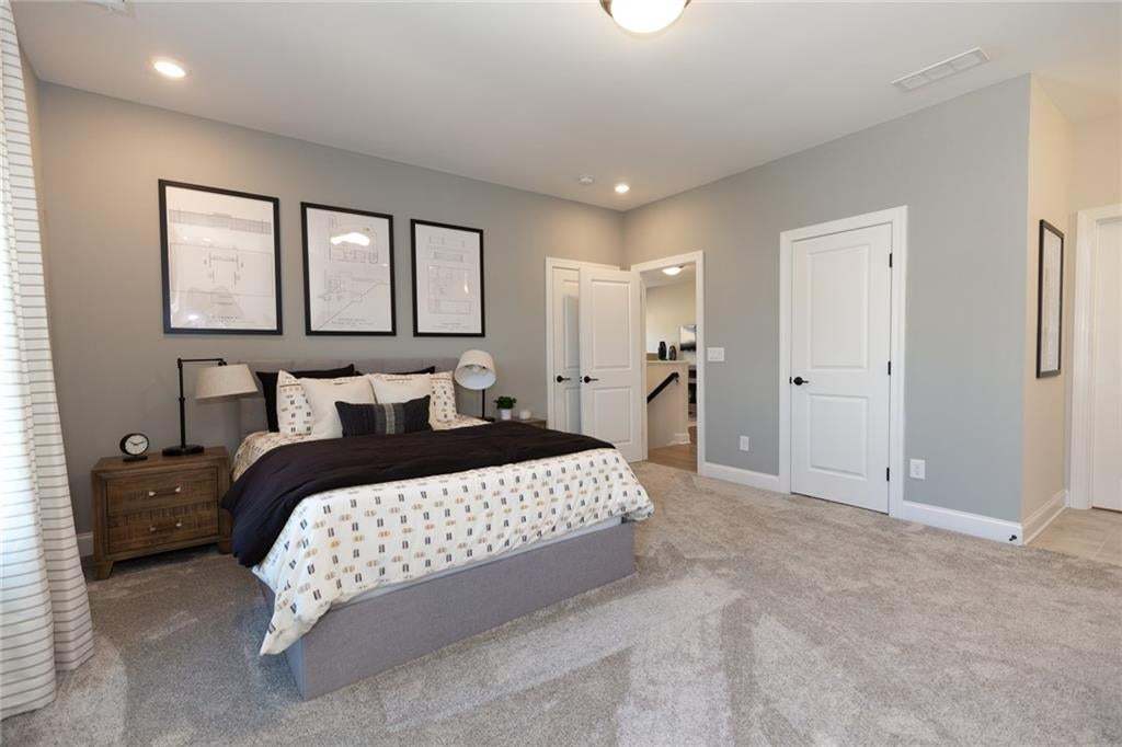 Recessed lighting, light-toned walls, and carpet flooring