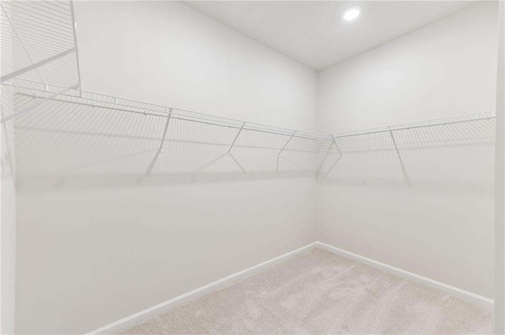 Walk-in closet featuring wire shelving, recessed lighting, neutral wall tones, and carpet flooring