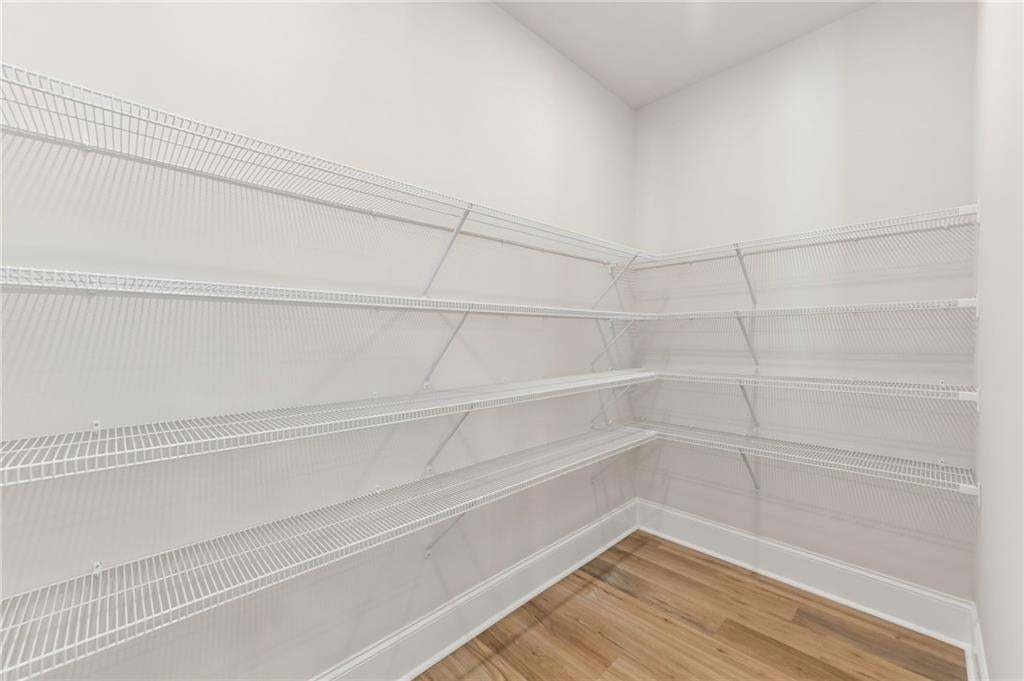White wire shelving, wood-finish flooring, white walls, and white trim