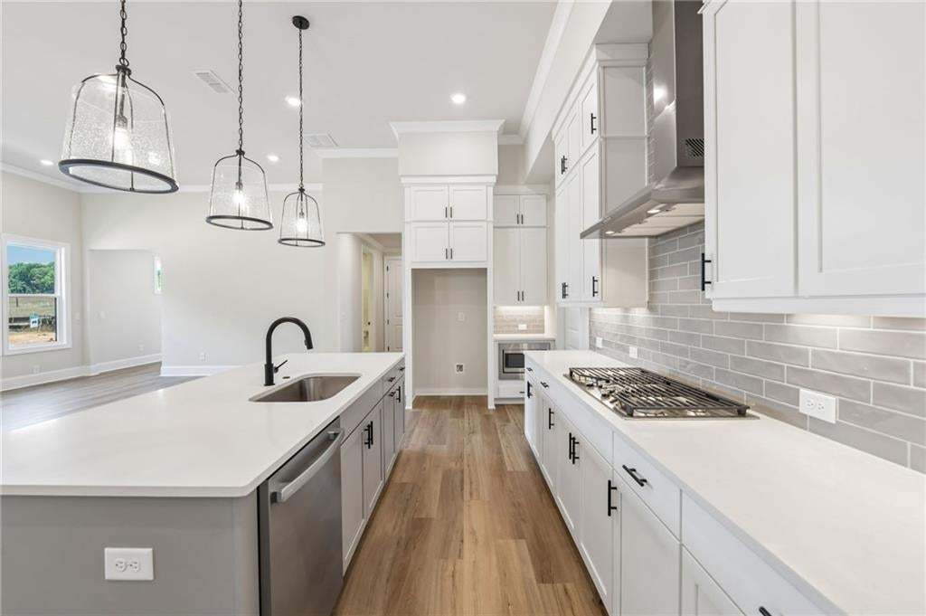 Modern kitchen featuring white cabinetry, light-toned wood-finish flooring, and white countertops