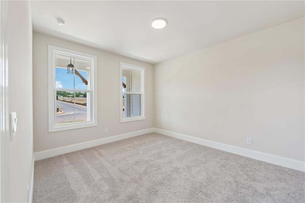 Wall-to-wall carpeting, dual windows with white trim, and a ceiling-mounted light fixture