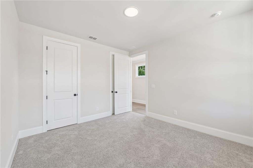 Recessed ceiling lighting, light gray wall finish, carpeted flooring, white trim, and white paneled doors