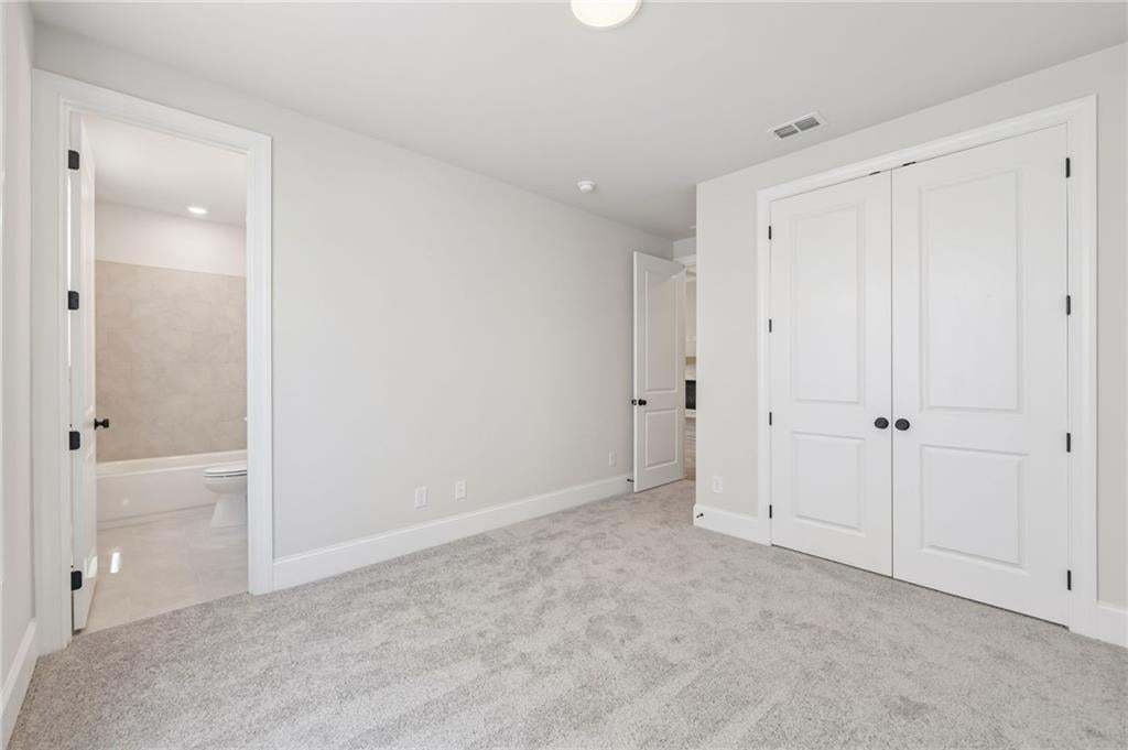 Light gray carpet flooring, white walls, white trim, recessed lighting, and white panel doors