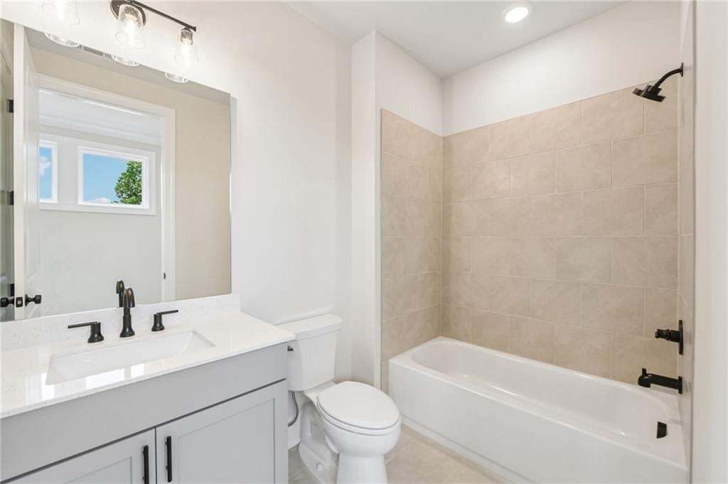 Vanity with a quartz countertop, integrated rectangular sink, and matte black faucet