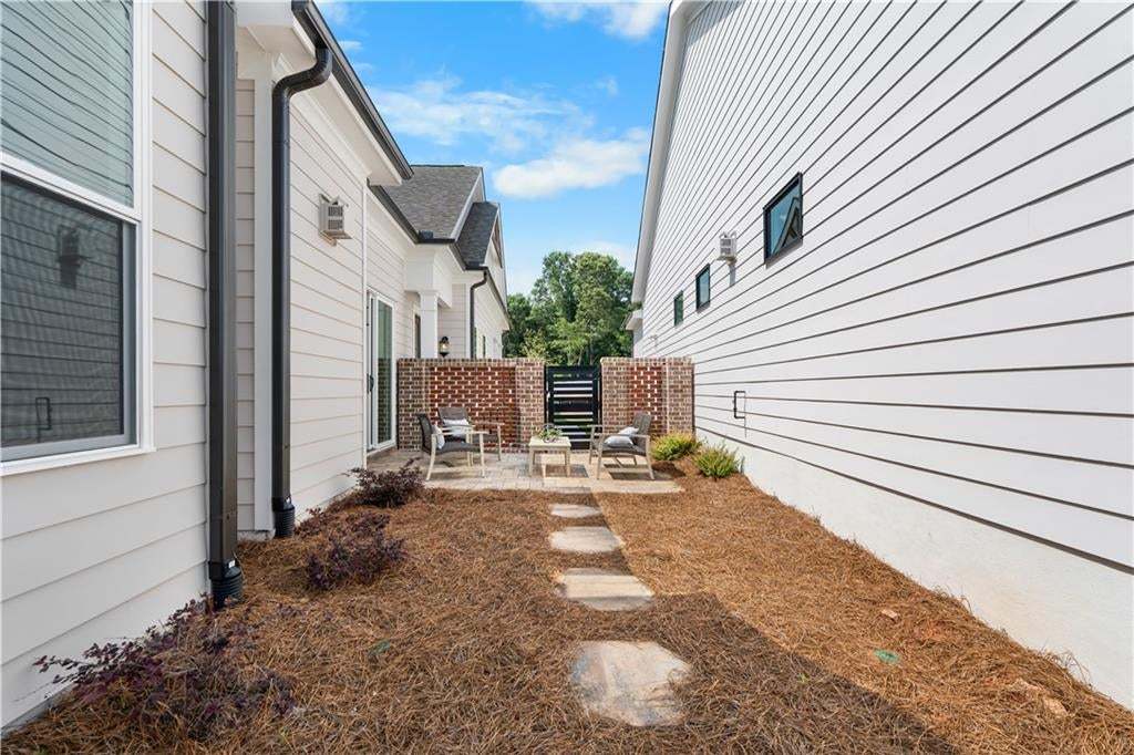 Exterior courtyard leading back to the spacious backyard.  All fenced in! Photo not of actual home but a similar TPG previously built home.