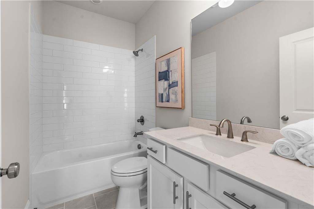Bathroom upstairs servicing the two secondary bedrooms. Love the size of the cabinet with all the storage. Photo not of actual home but a similar TPG previously built home.