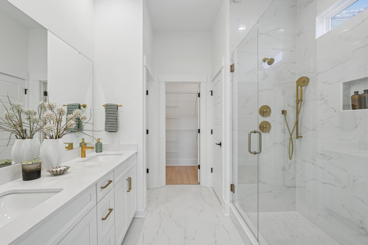Spa-like primary bathroom with dual-sink vanity, luxe walk-in shower, and private water closet