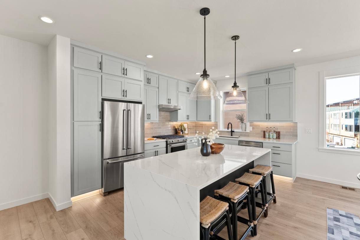 Kitchen features a gorgeous island with waterfall edge