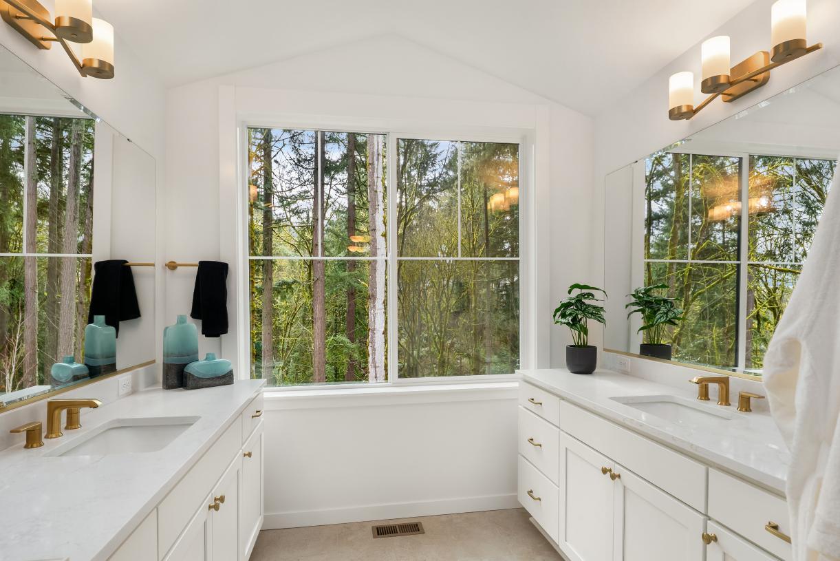 Luxe primary bathroom with vaulted ceiling and separate vanities