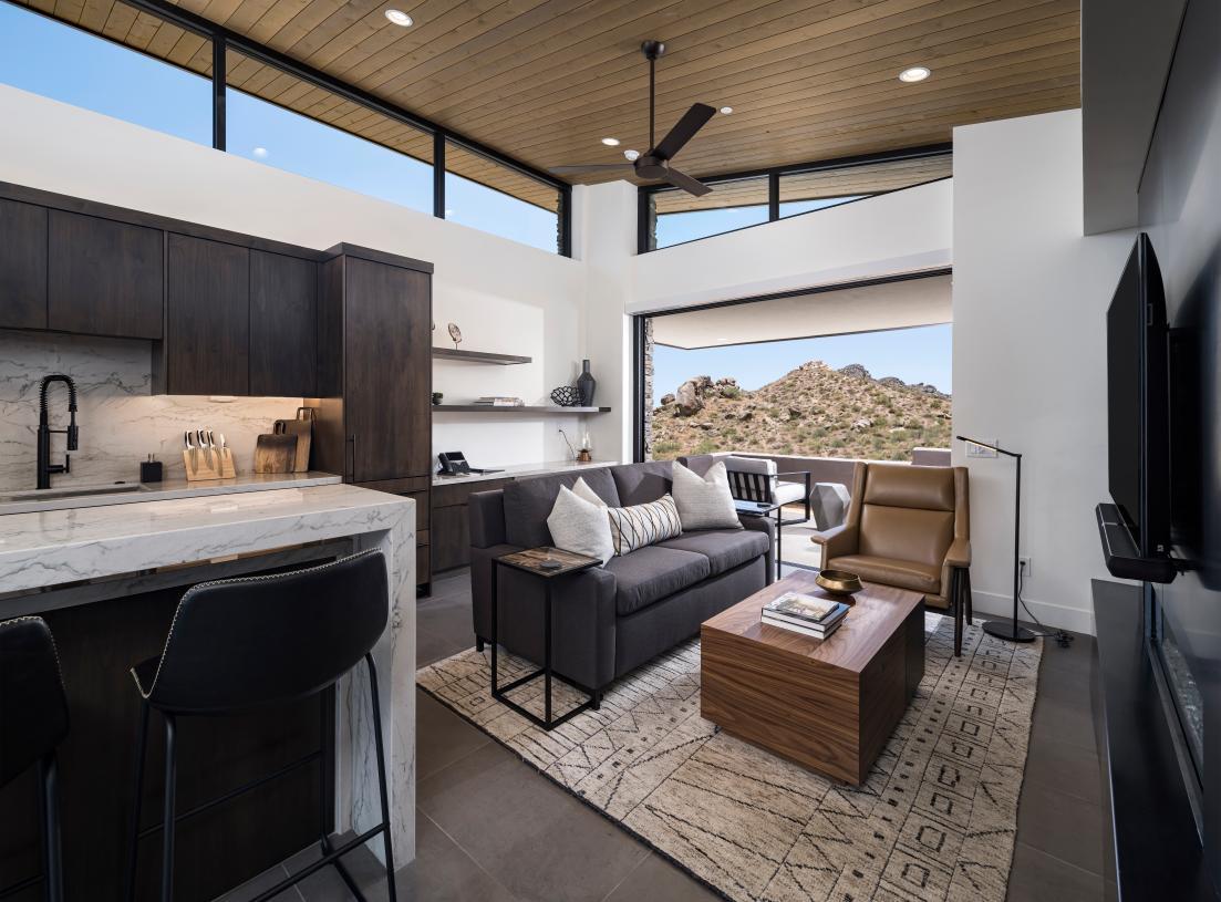 Open great room with fireplace, vaulted ceilings, and multi-slide patio door