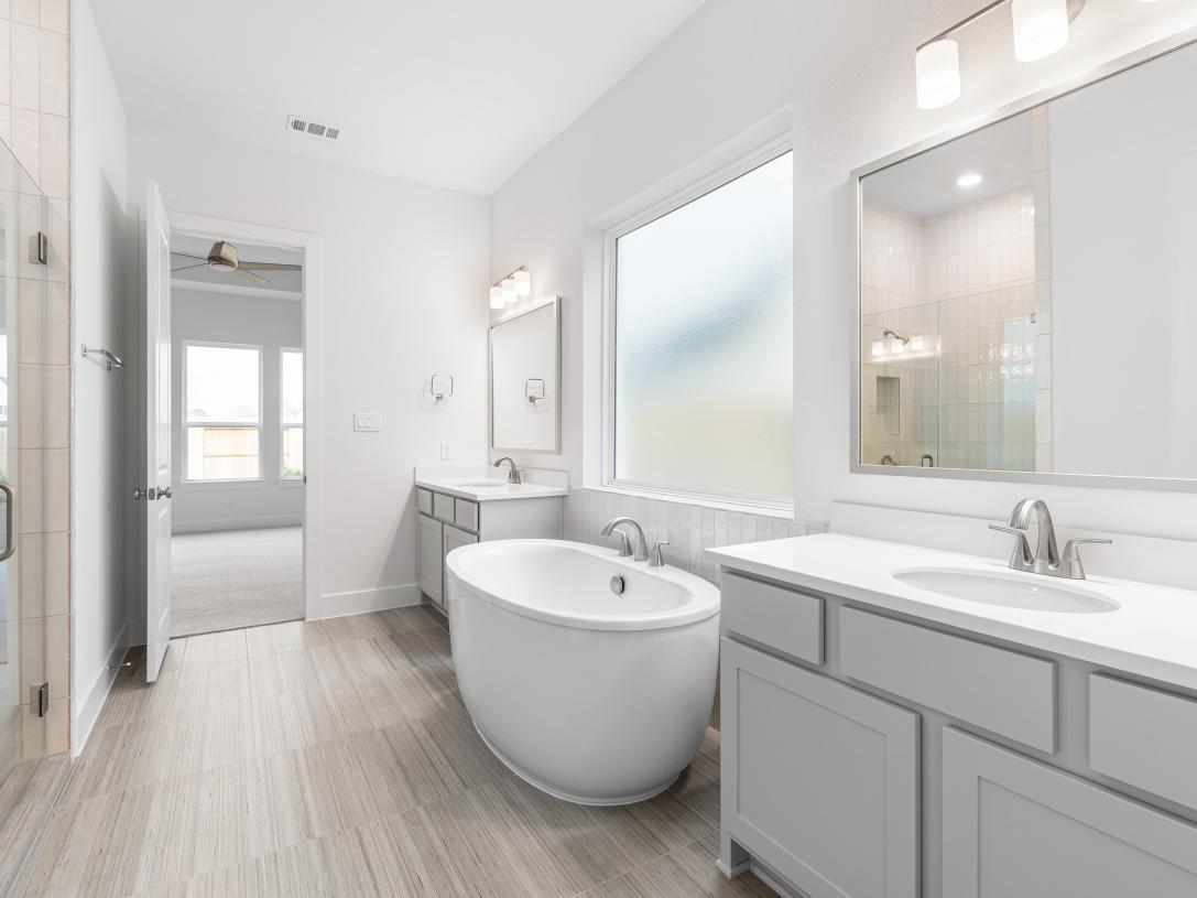 Primary bathroom with his and her sinks and standalone tub