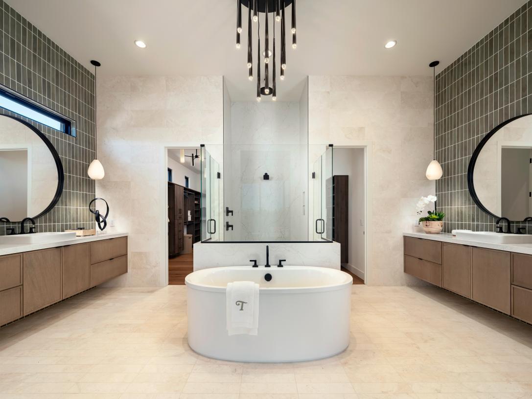Spa-inspired primary bathroom with soaking tub, glass shower doors, and expansive walk-in closet