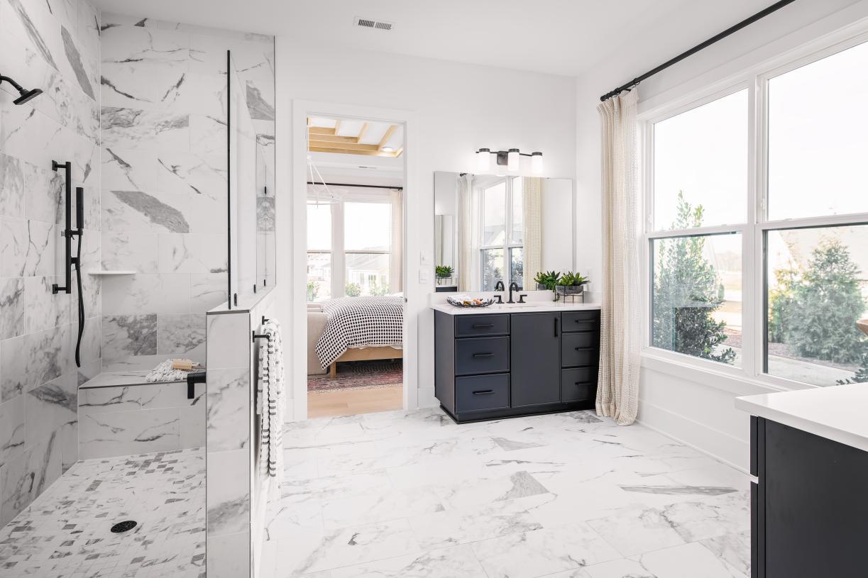 Spa-like primary bath featuring a zero-threshold shower and dual vanities