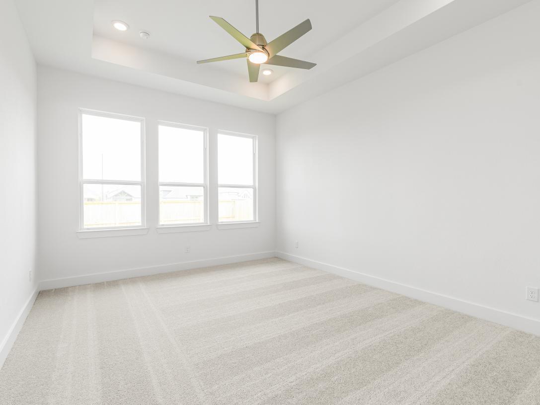 Large primary bedroom suite with ample natural light and a seating area