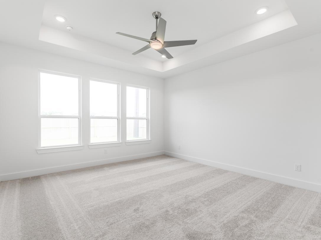 First-floor primary bedroom suite with tray ceilings
