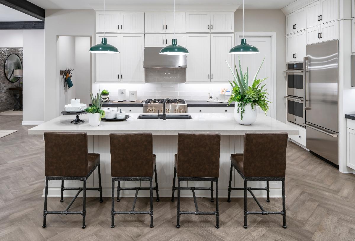 Elegant white kitchen with stainless steel appliances and large wet island