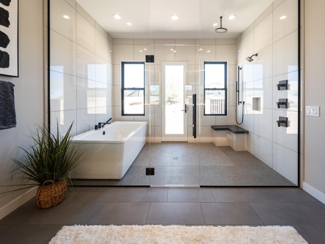 Spacious shower and standalone accentuate the striking primary bathroom in this home