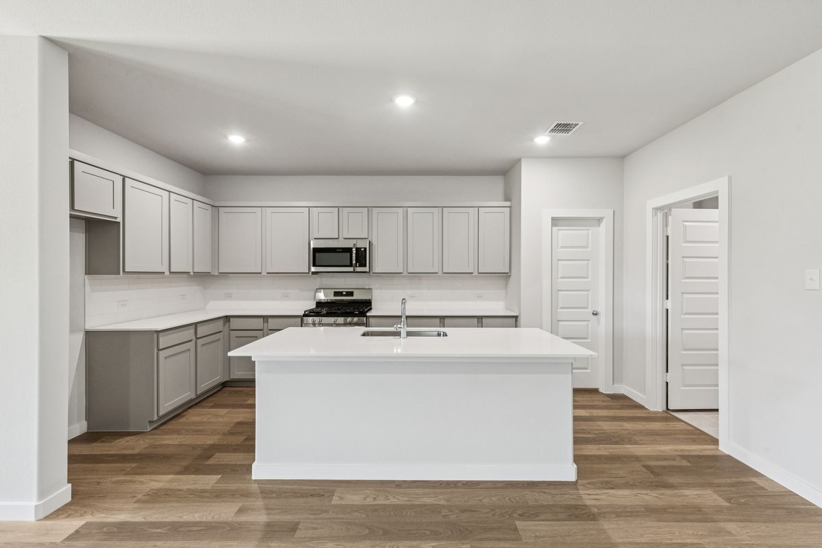 Kitchen in the Oscar home plan by Trophy Signature Homes – REPRESENTATIVE PHOTO