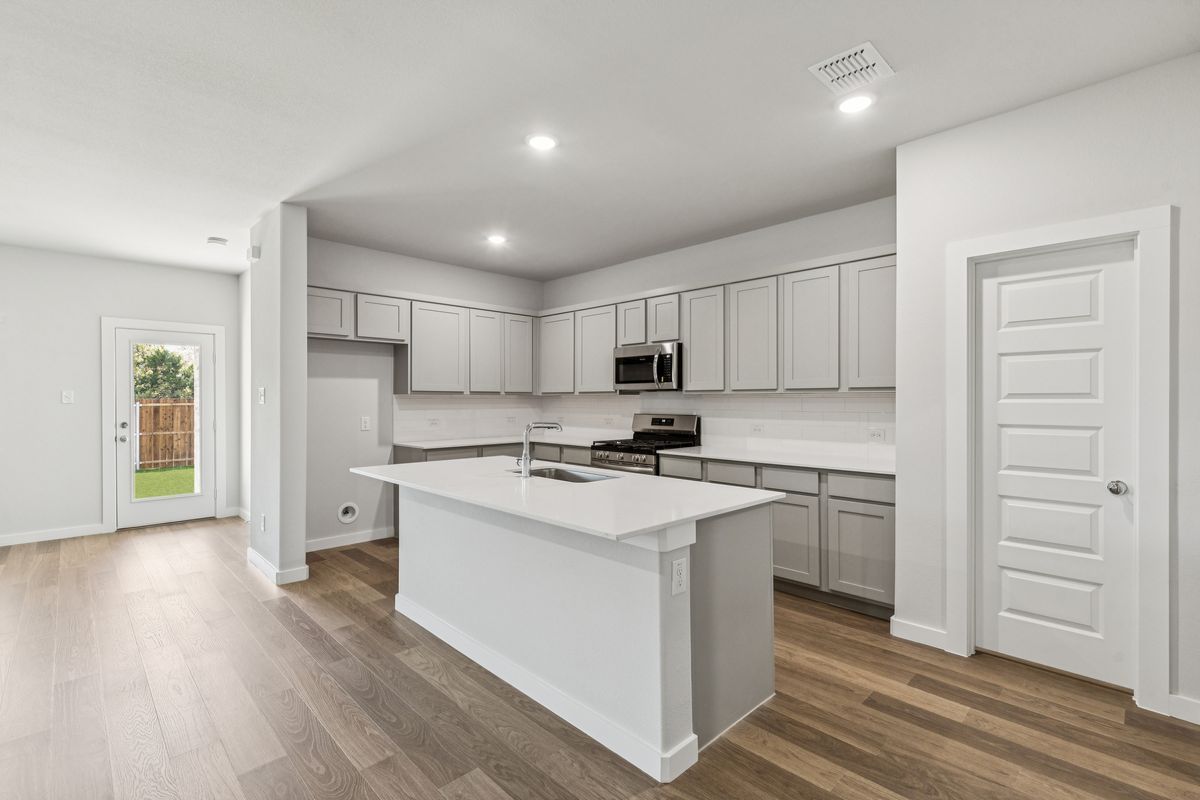 Kitchen in the Oscar home plan by Trophy Signature Homes – REPRESENTATIVE PHOTO