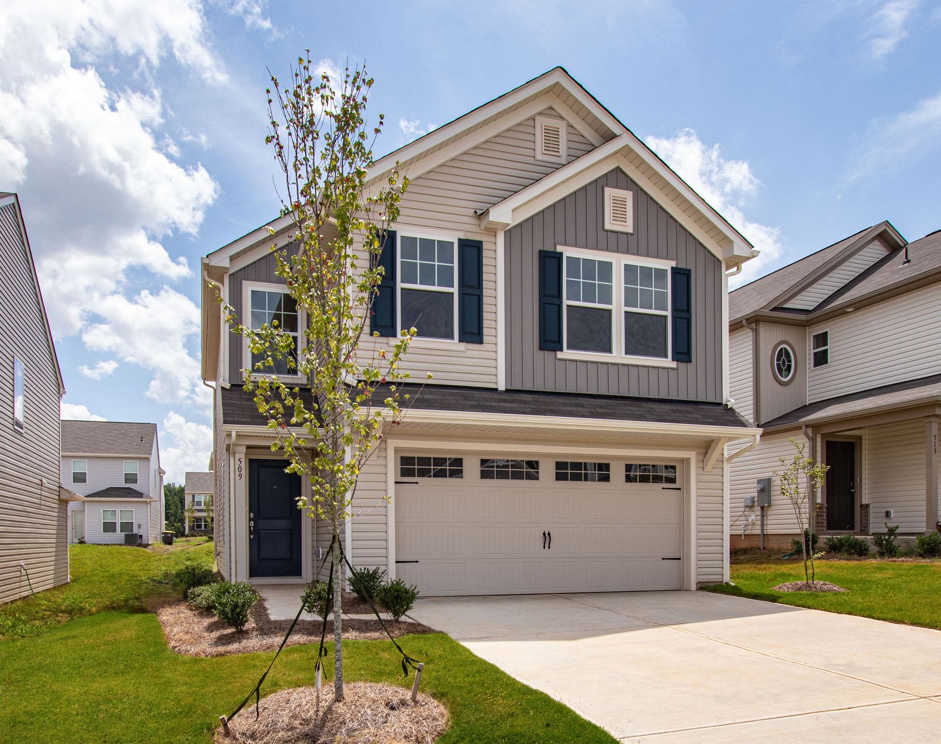 A large house with a large garage and a blue door