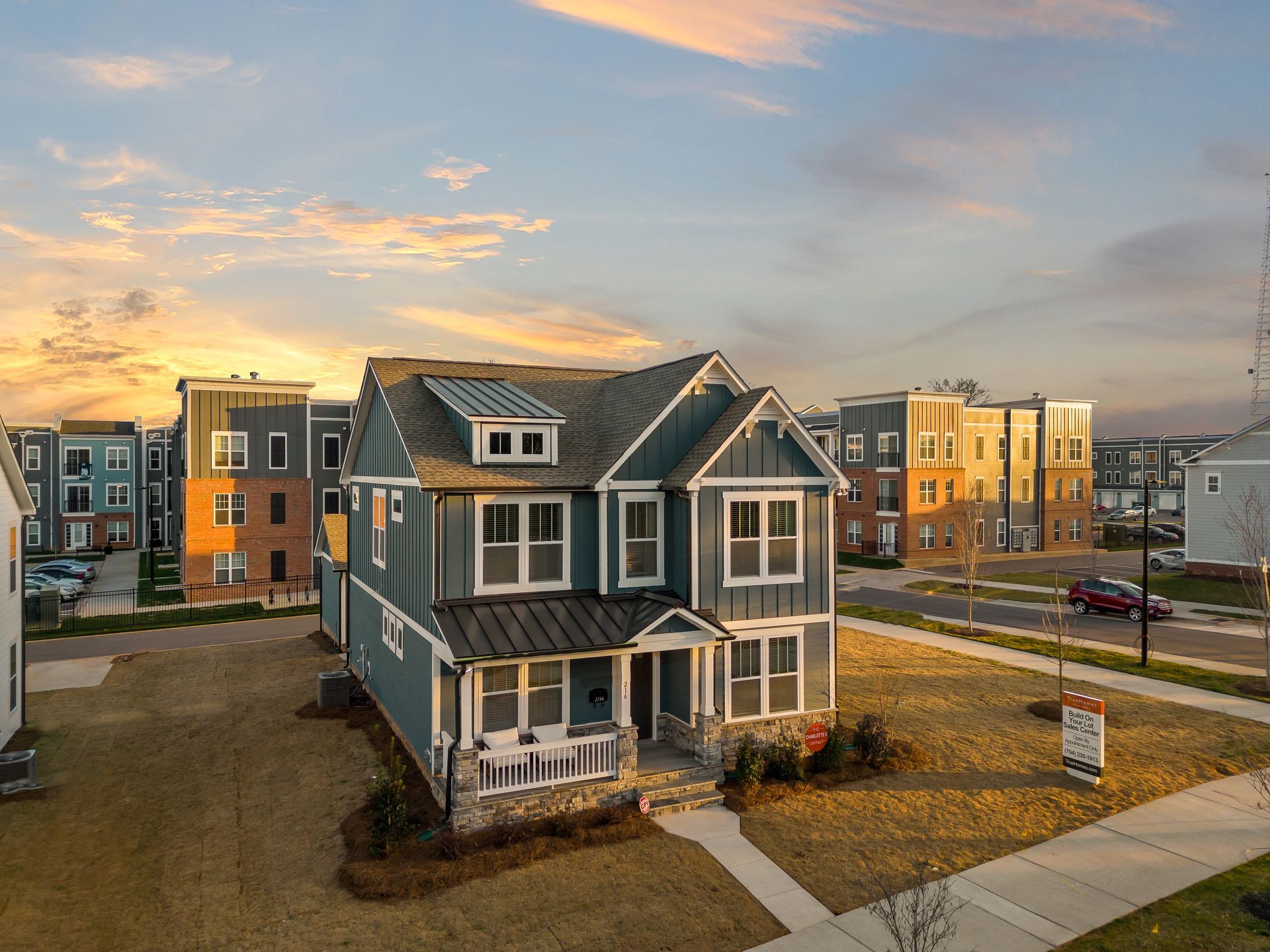 An aerial view of a house in a residential area at sunset.