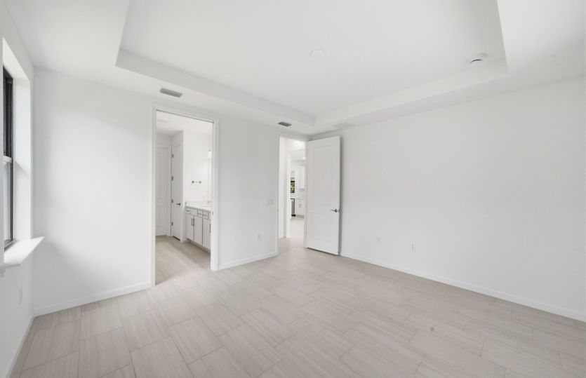 Owner's suite featuring a drop tray ceiling