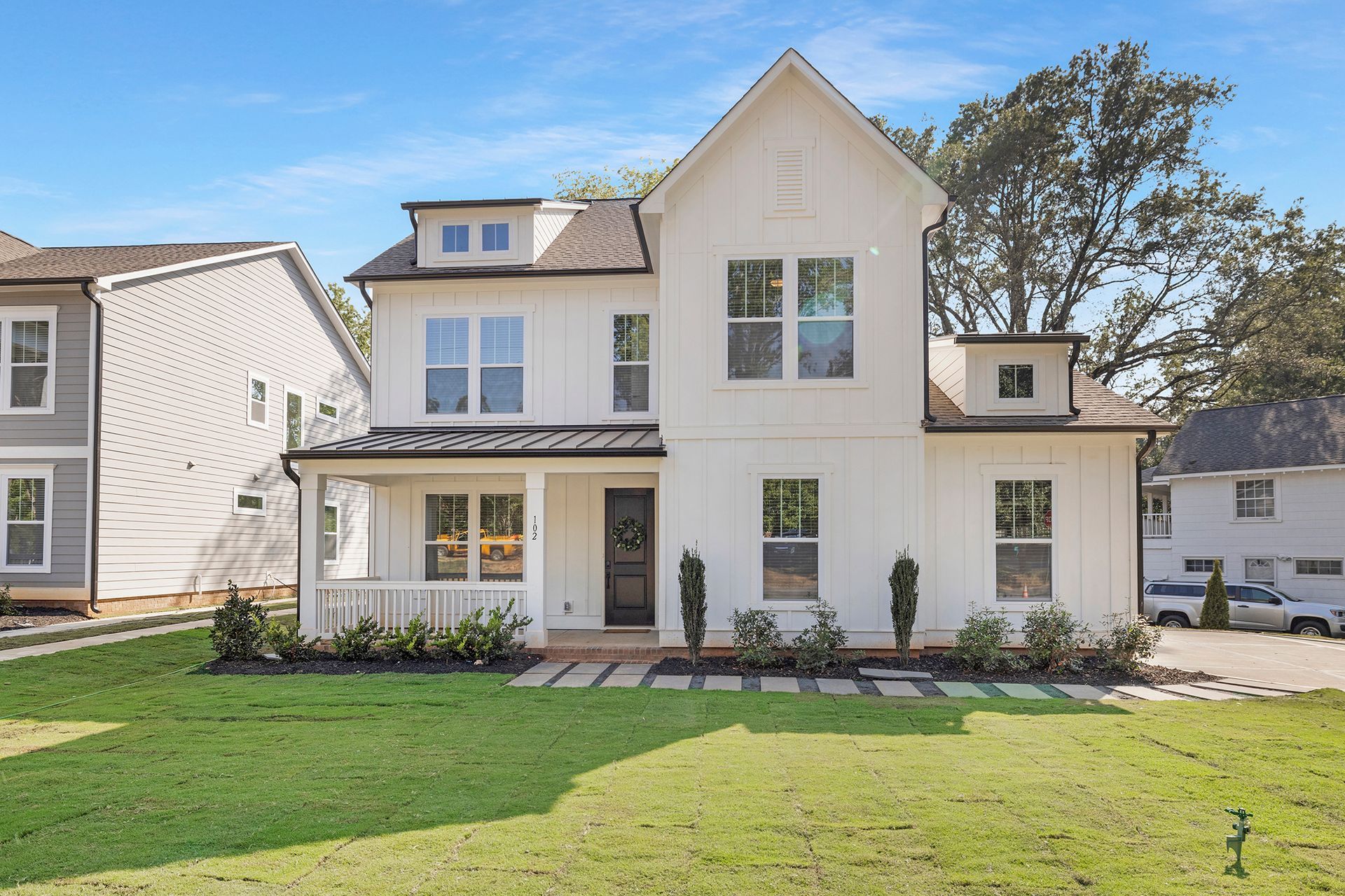 A large white house with a lot of windows is for sale.