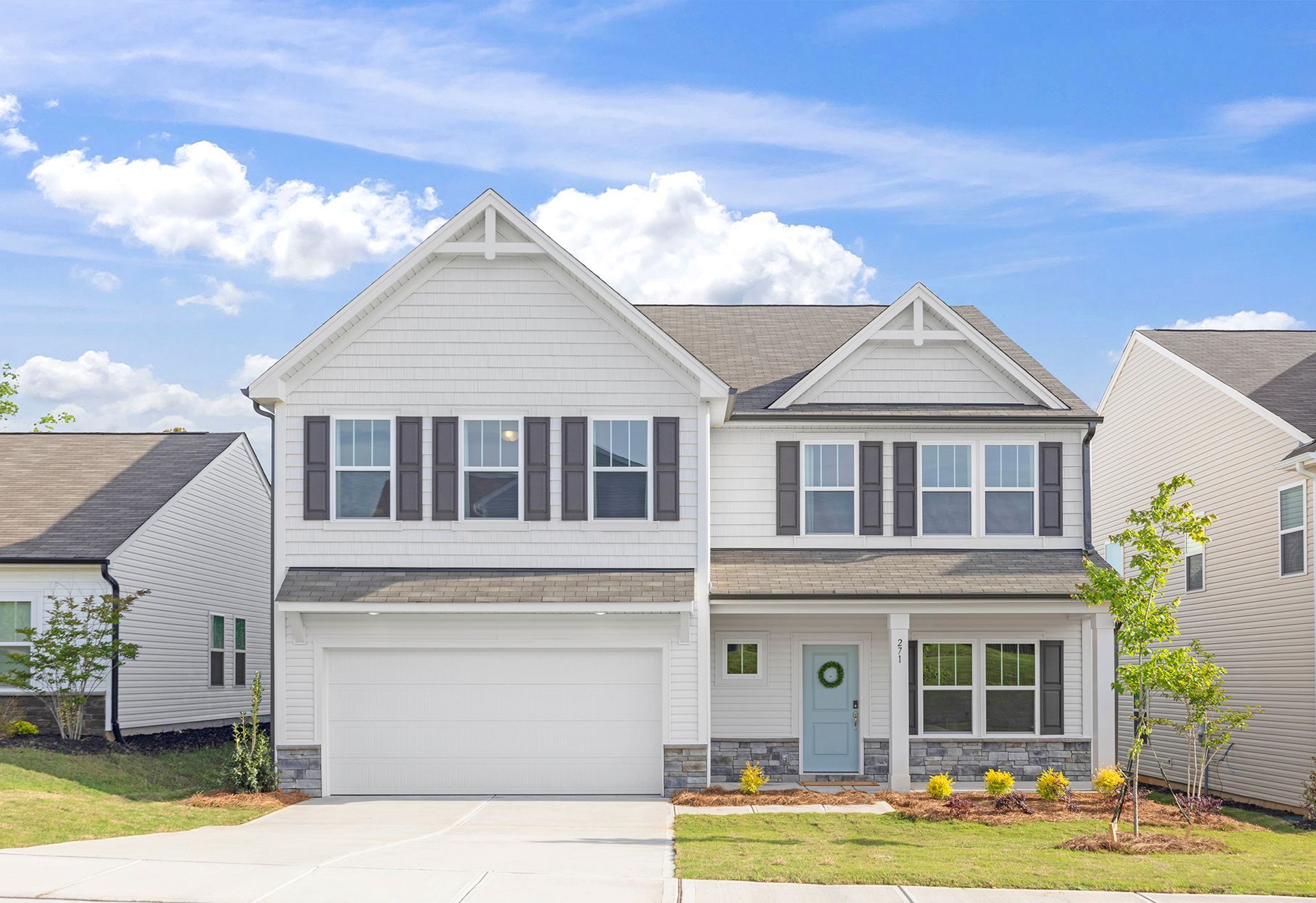 A white house with black shutters and a blue door is for sale.