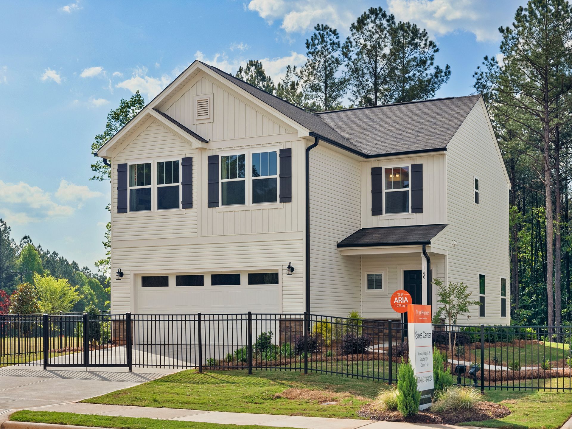 A white house with black shutters is for sale