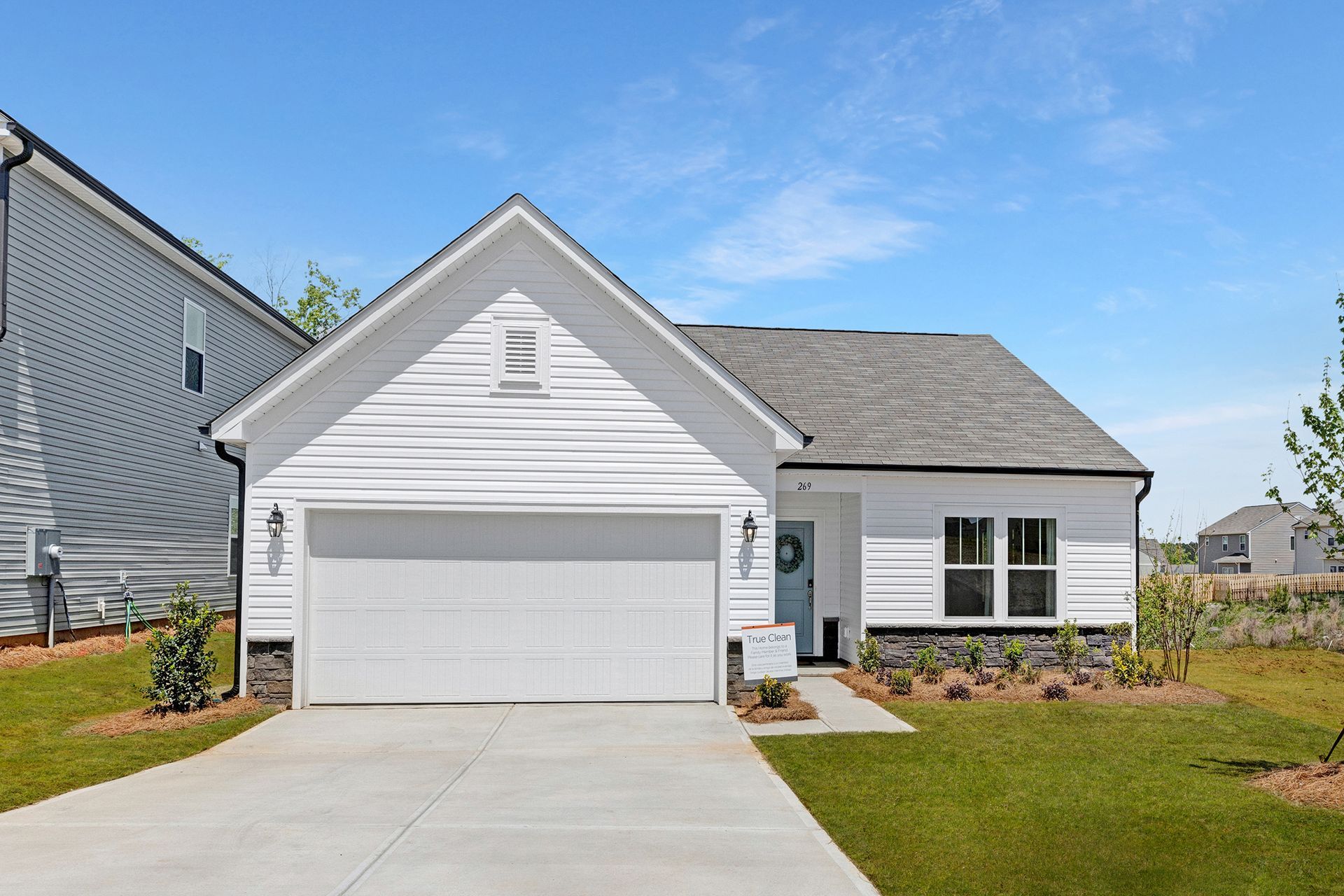 A white house with a garage and a driveway in front of it.