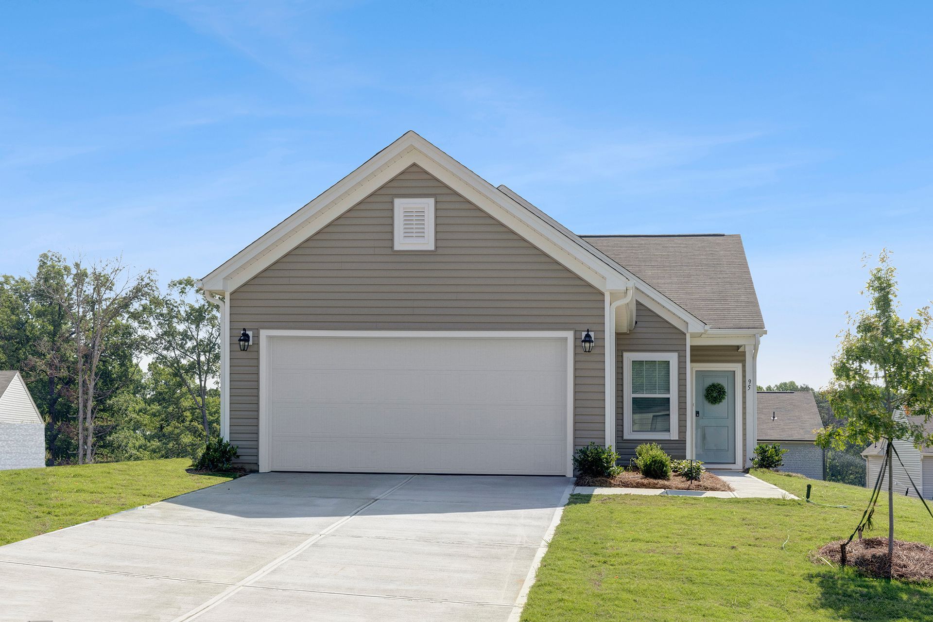 A house with a garage and a driveway in front of it.