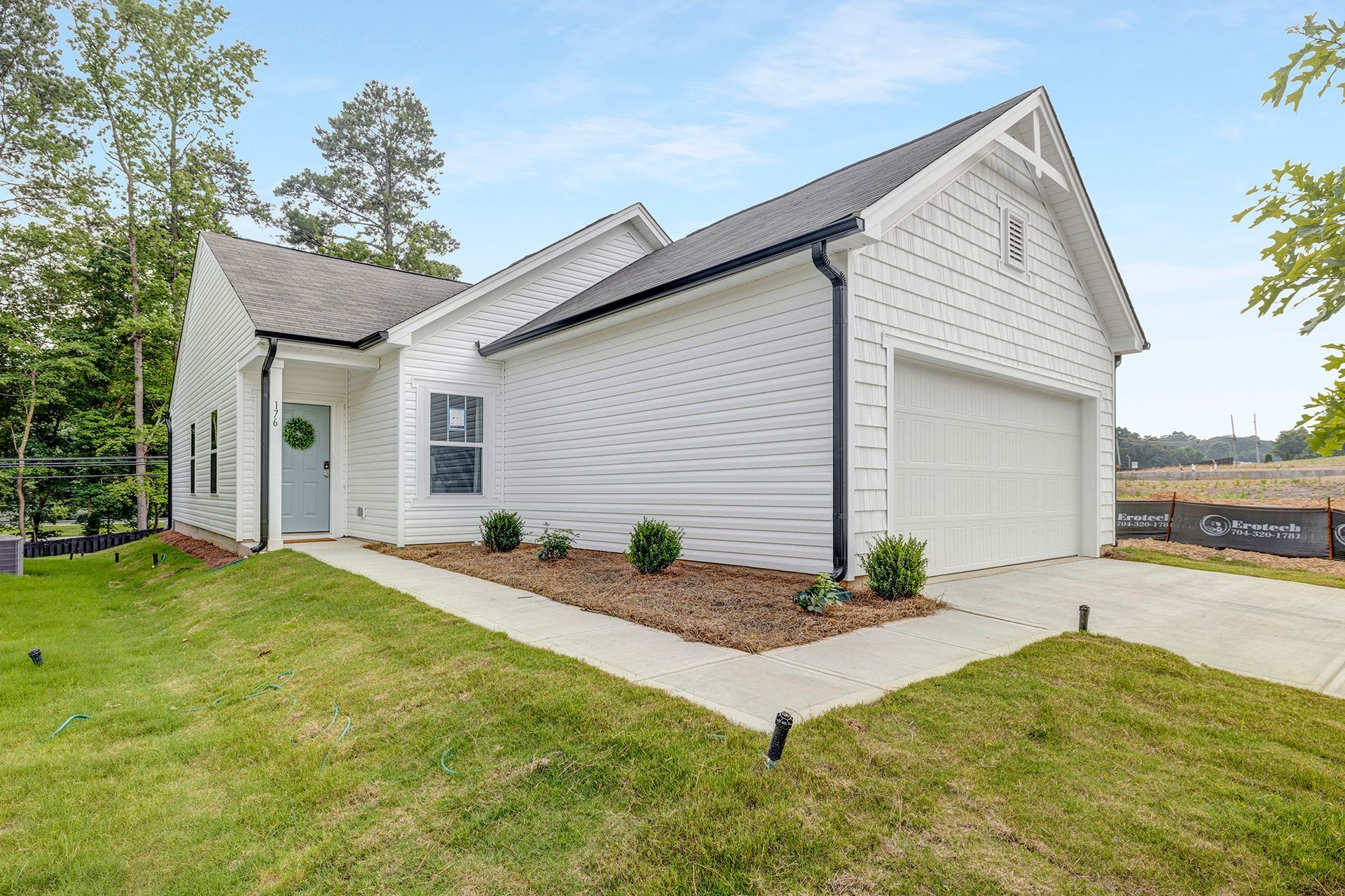 A white house with a garage and a walkway in front of it.