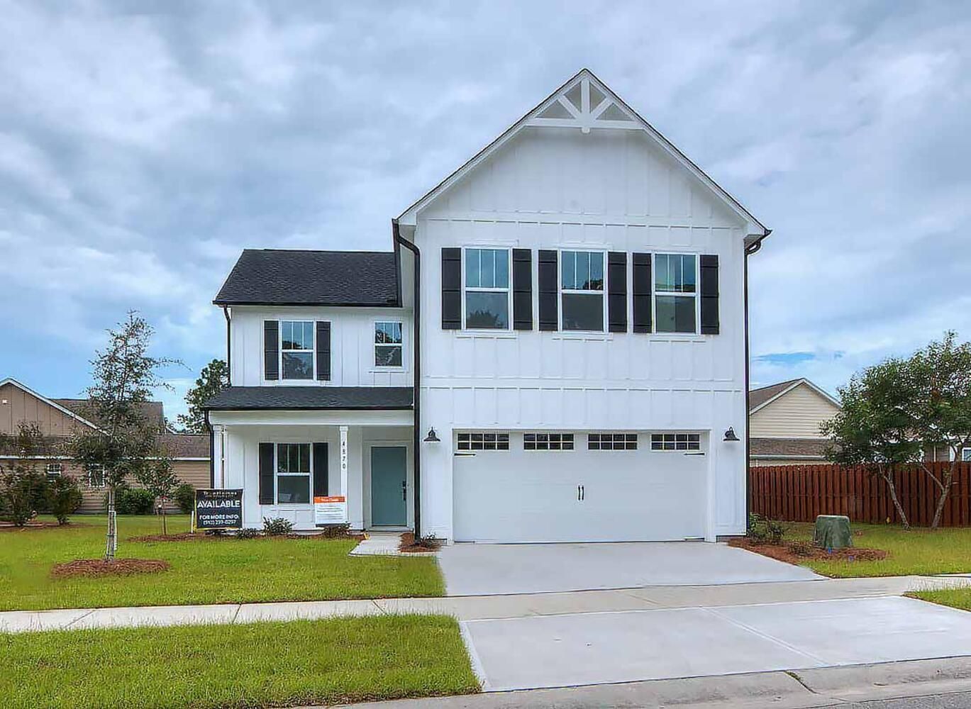 A white house with black shutters and a large garage.
