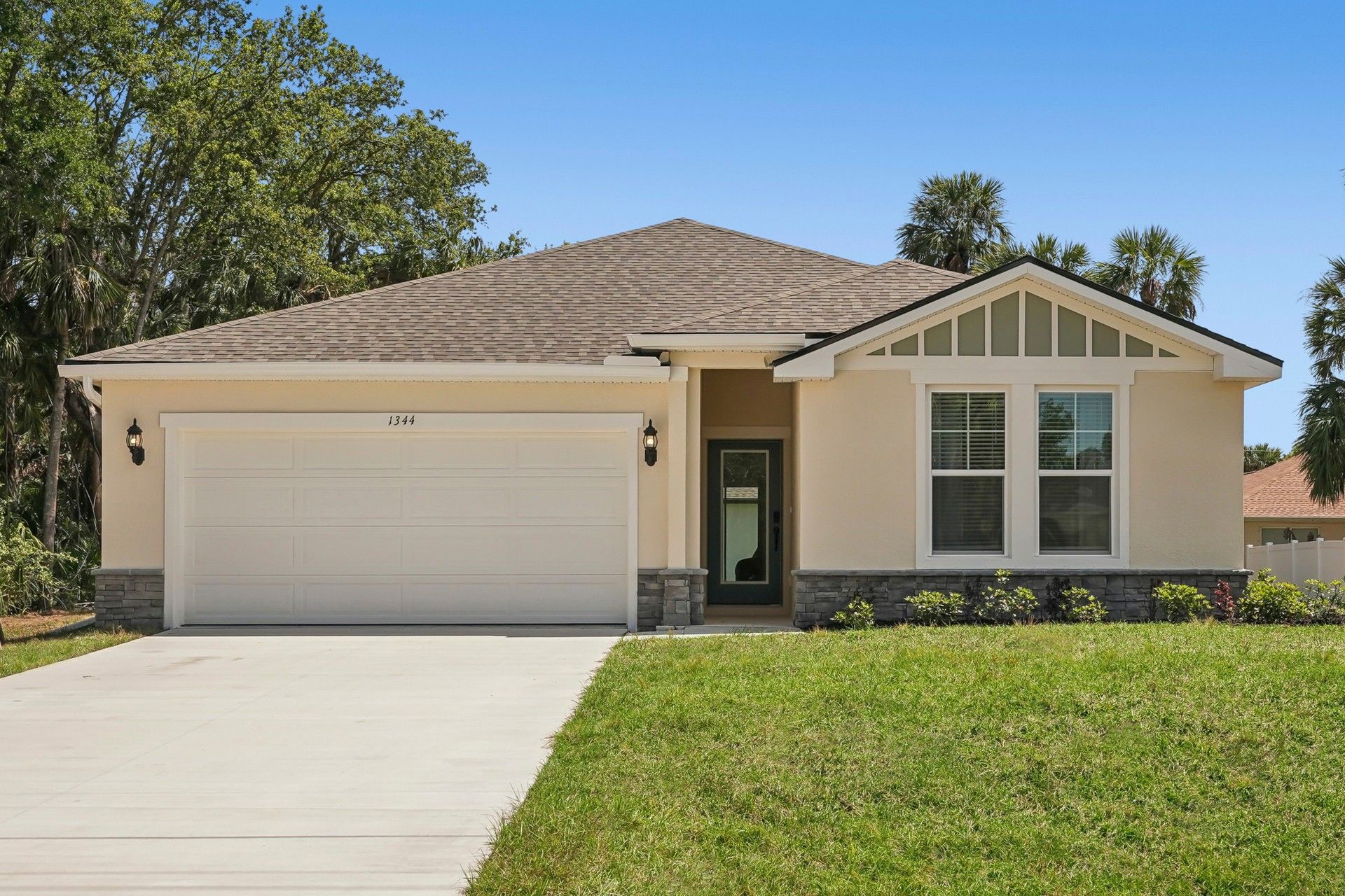 Elegant Single-Story Home with Stone Accents in North Port:Luxurious North Port home featuring gabled roof and refined stone facade for timeless elegance.