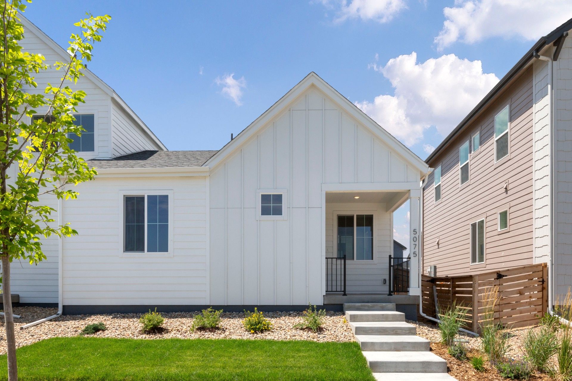 Modern Two-Story House with Garden at Caraway, Trailside on Harmony:Elegant board and batten facade and pristine lawn define this Caraway estate at Trailside on Harmony.