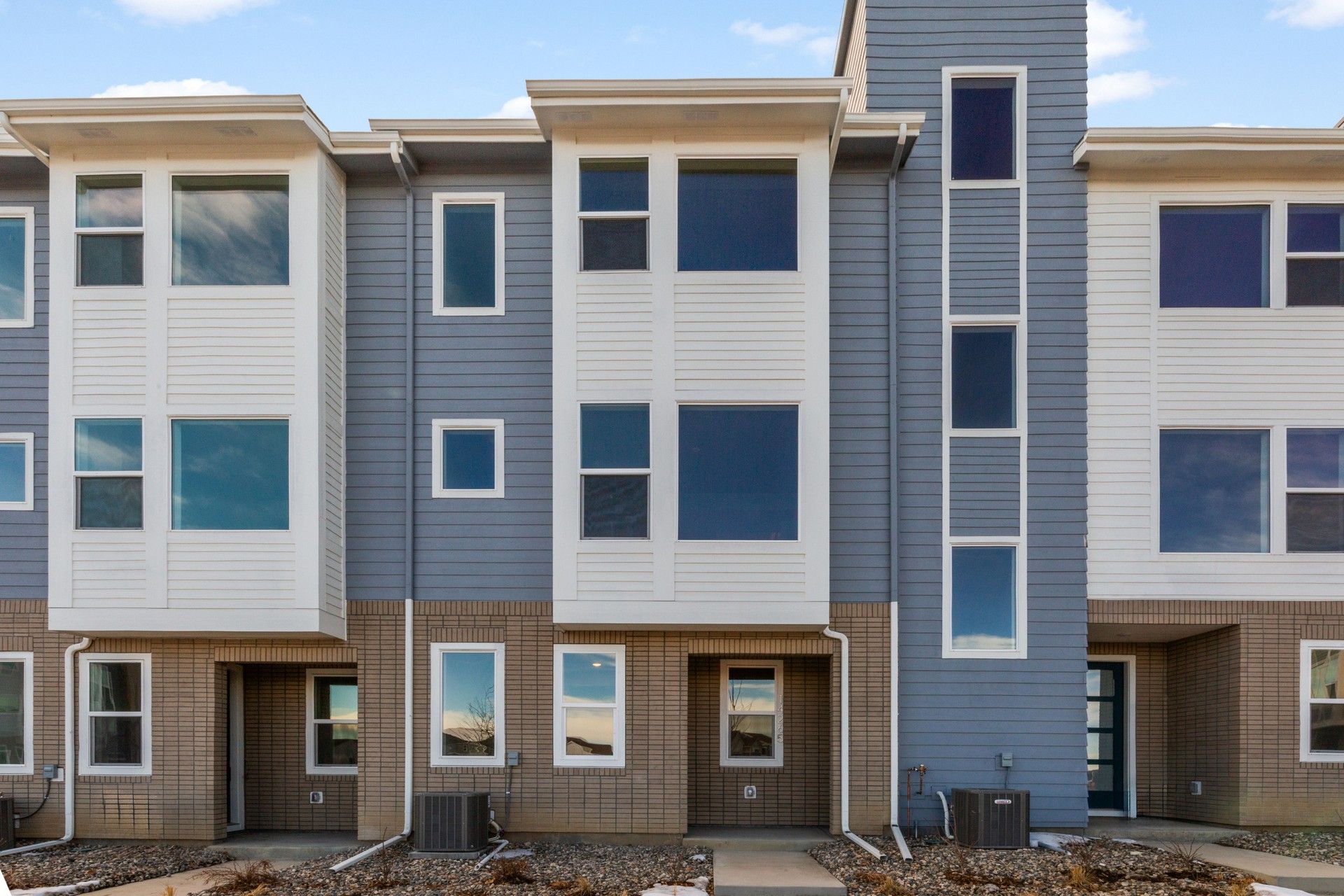 Contemporary Townhouses at Antora Dillon Pointe:Elegant townhomes feature chic gray and white siding, expansive windows at Antora, Dillon Pointe.
