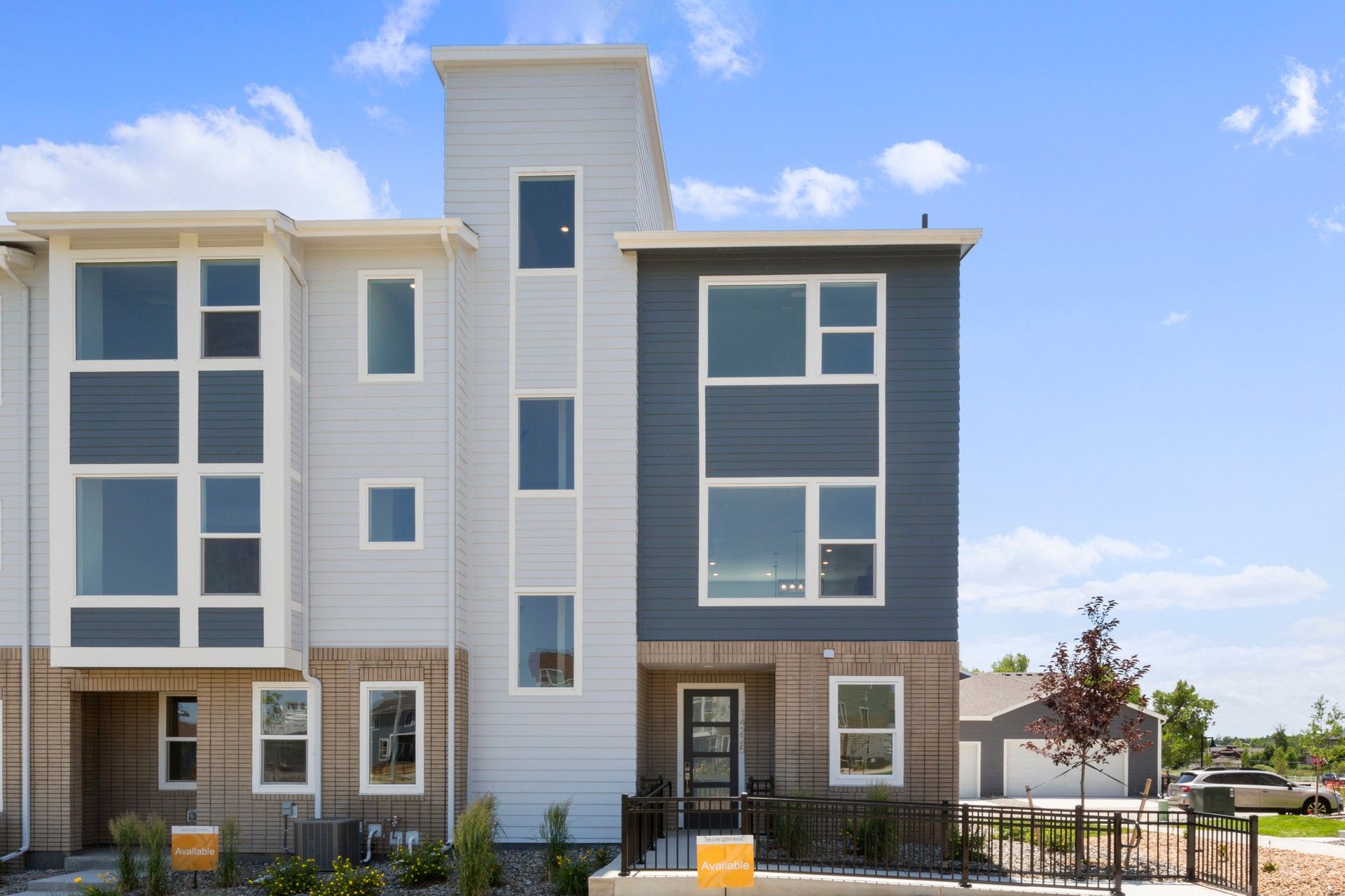 Modern Townhouse in Columbia at Dillon Pointe with Stylish Facade:Elegant three-story townhouse in Columbia at Dillon Pointe features sleek siding and expansive windows for modern luxury.