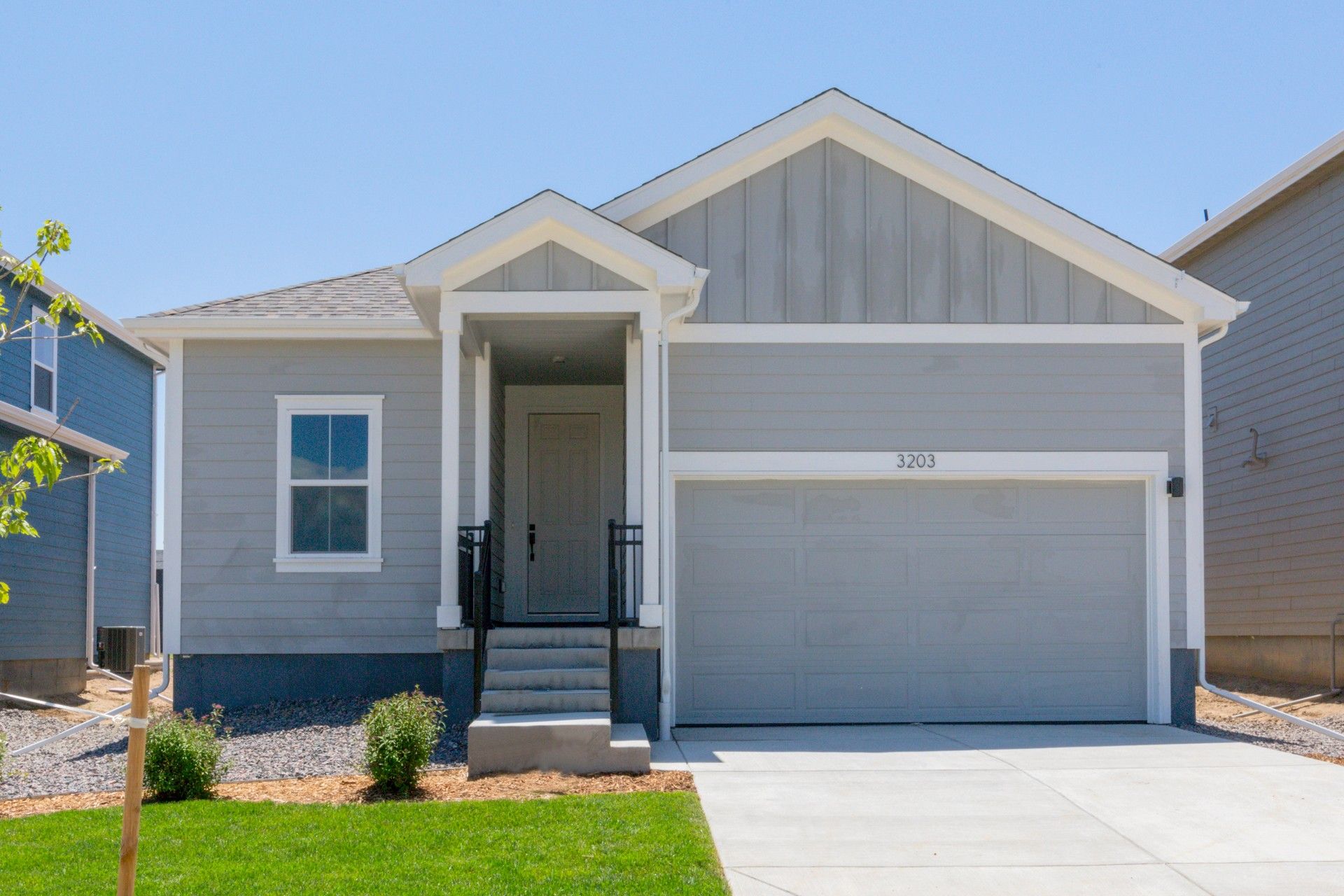 Modern Grey Bungalow in Honeysuckle at Bloom Community:This elegant suburban bungalow boasts a refined gable roof and charming front porch. Located in Honeysuckle at Bloom.