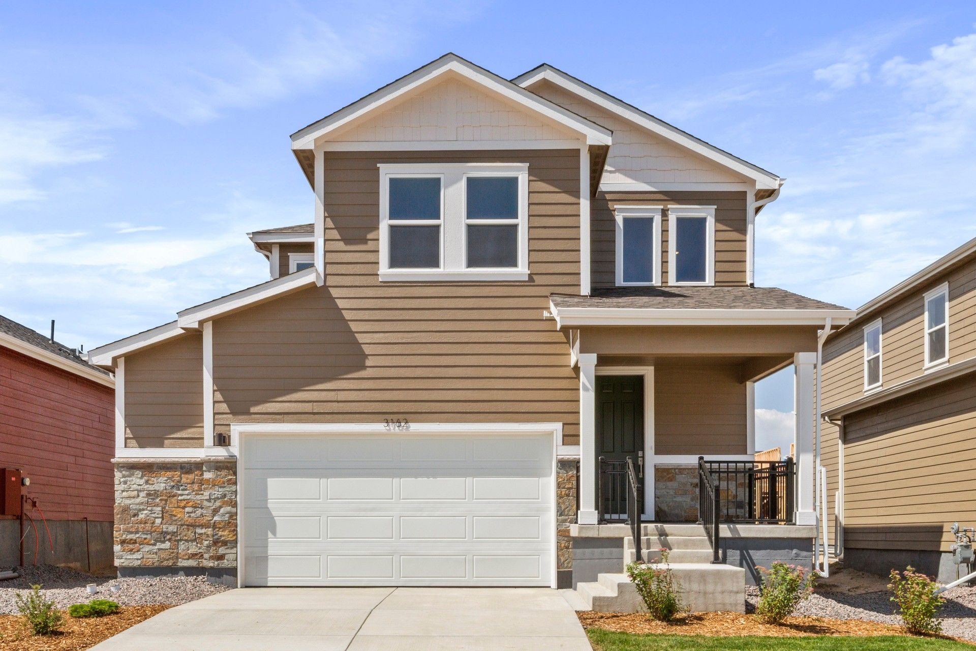 Modern Two-Story Home with Stone Accents in Suburban Area:Elegant two-story architecture with stone accents and spacious garage exuding suburban luxury.