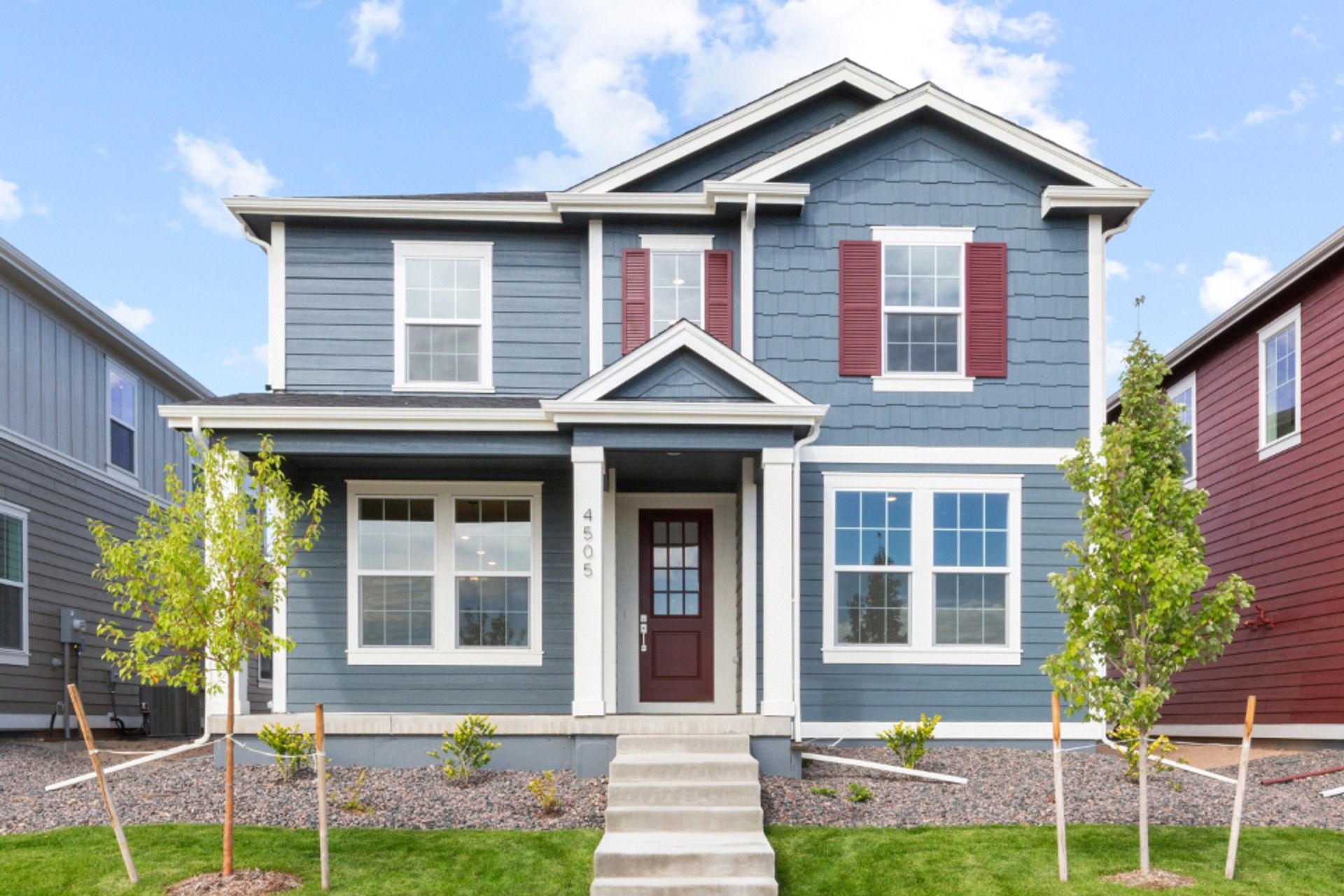 Modern Blue Two-Story Home in Timnath Lakes with Red Shutters:Elegantly designed blue facade with striking red shutters and expansive windows in Timnath Lakes.