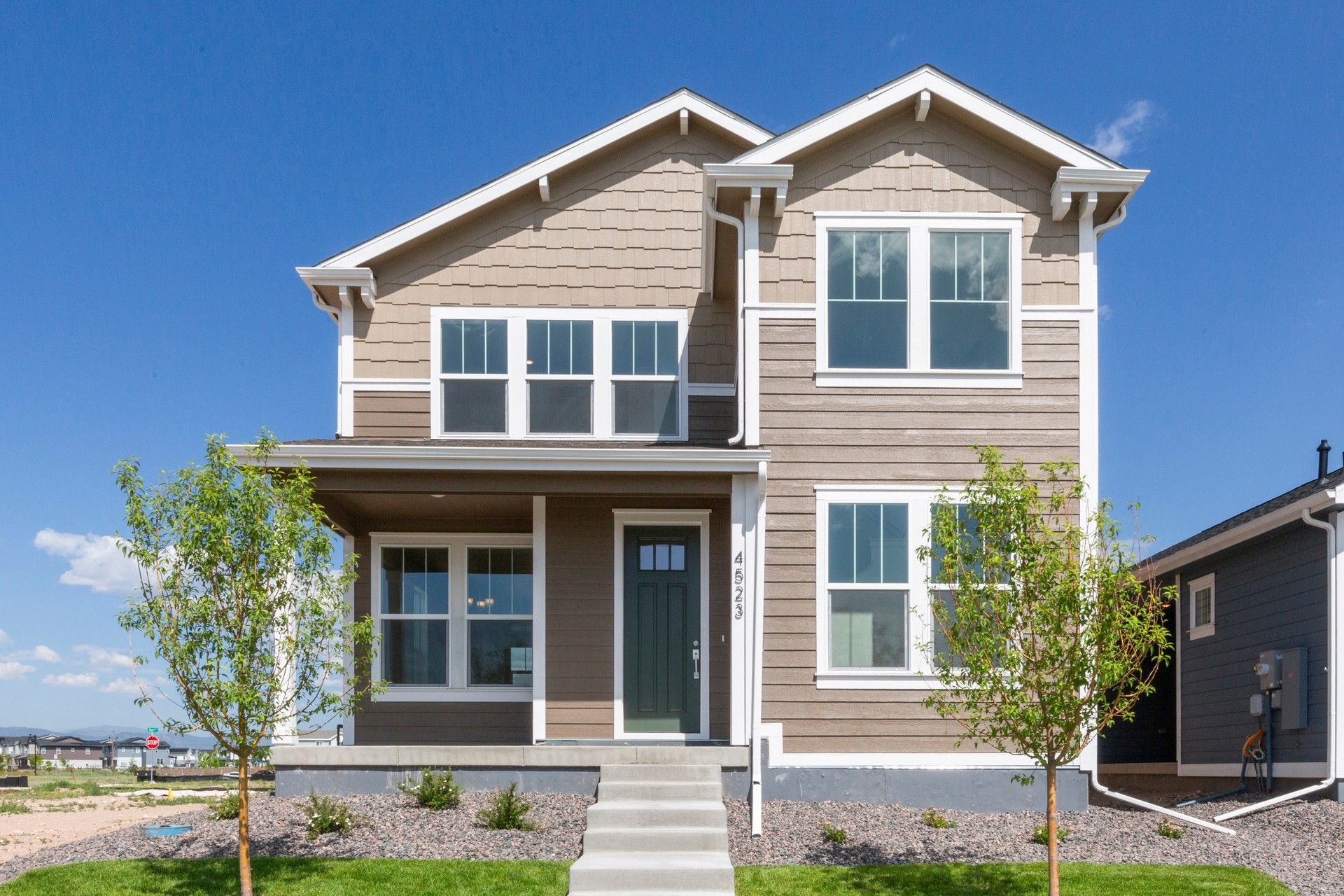 Modern Two-Story Home at Timnath Lakes with Beige Siding:Timnath Lakes home features chic beige siding, crisp white trim, and spacious porch, set against serene skies.