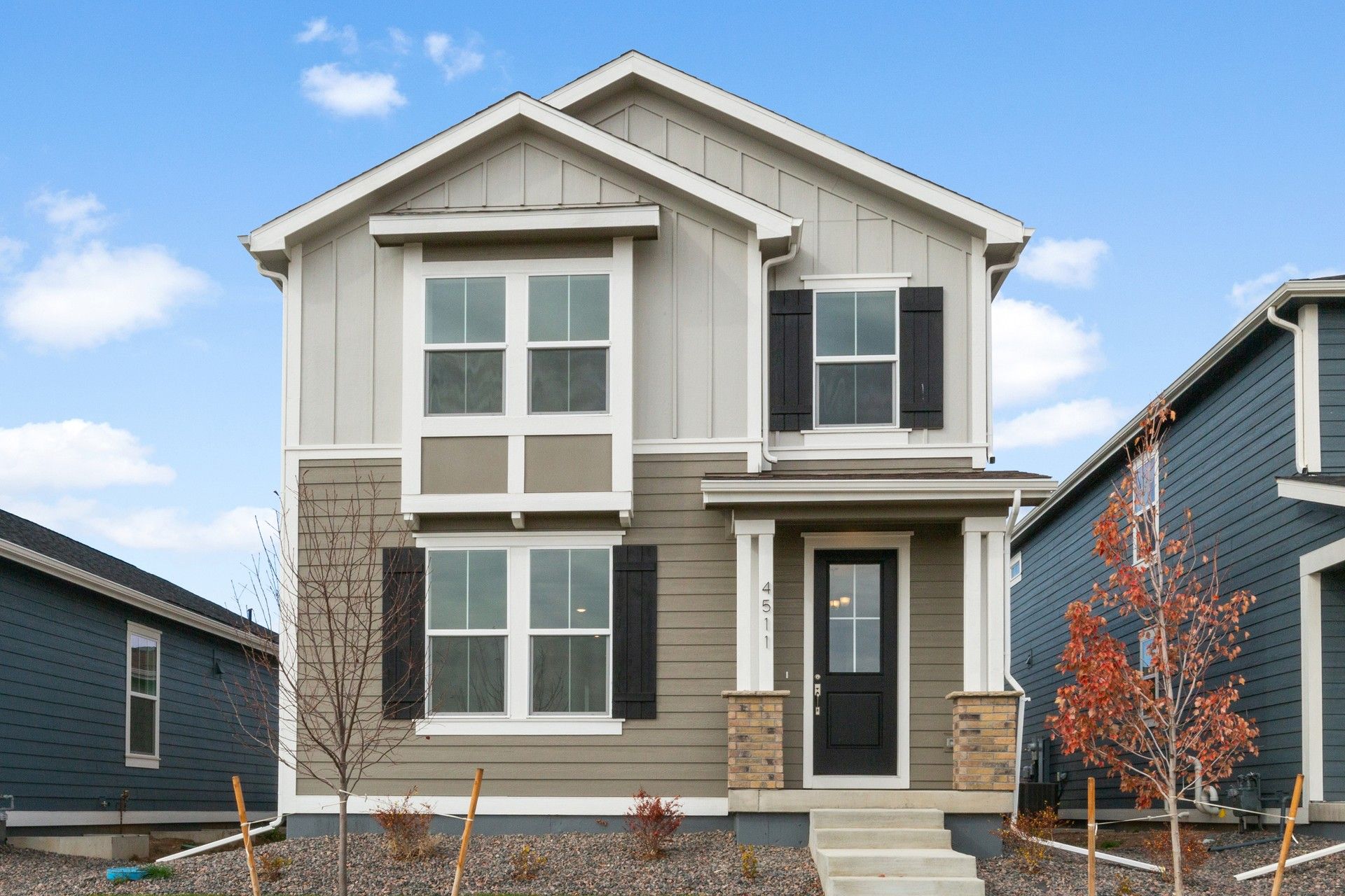 Modern Two-Story Home at Timnath Lakes with Gray Siding and Black Shutters:Timnath Lakes gem featuring striking gray siding, elegant black shutters, and expansive windows, exuding refined sophistication.