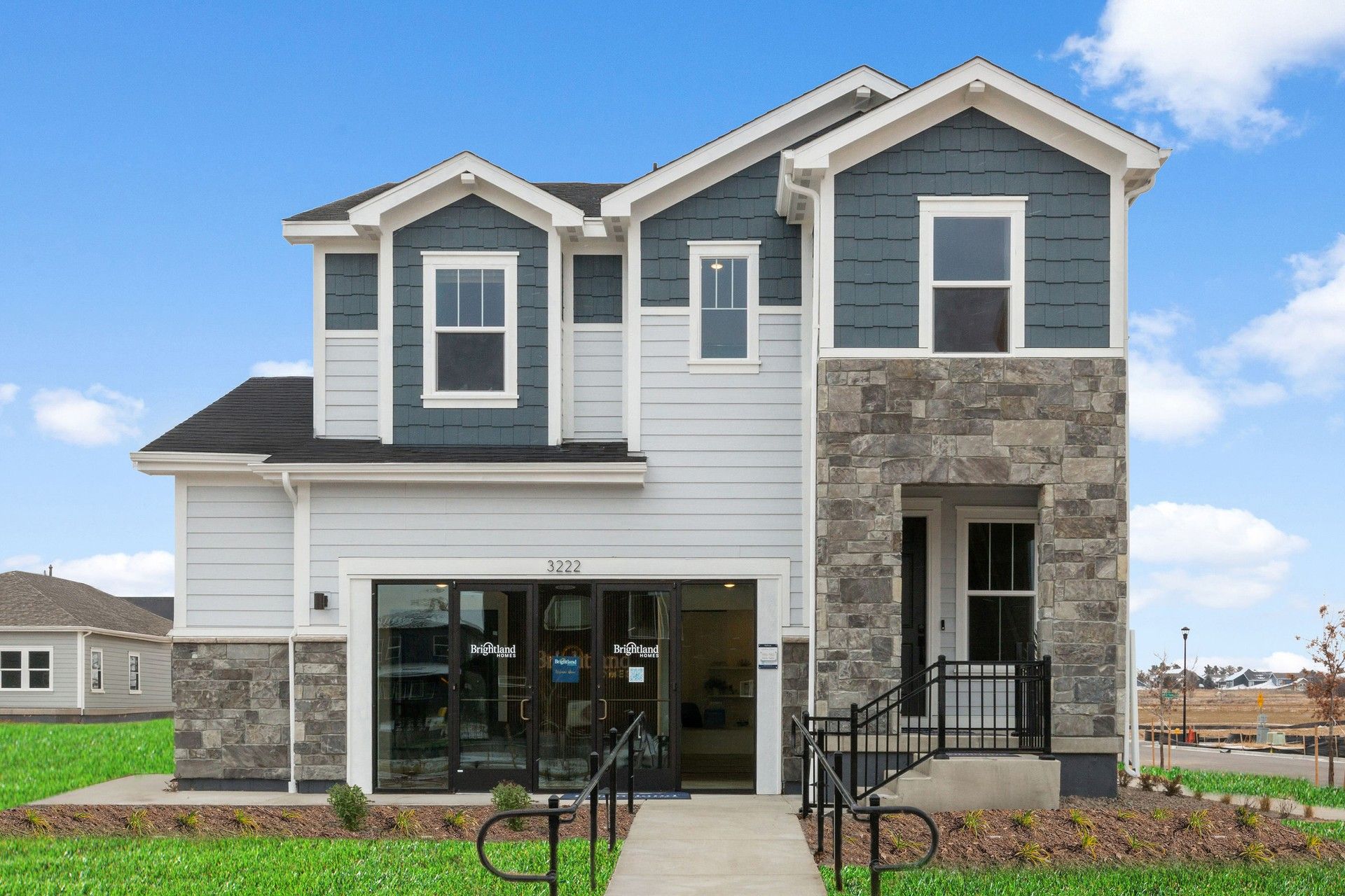 Modern Two-Story House with Stone Facade in Bloom Community:Exquisite stone facade complements elegant blue siding, creating a chic aesthetic in the Bloom community.